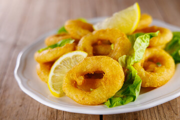 Crispy Fried Calamari Rings with Lemon and Food on a Table