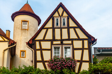 large building with a tower and a house with a flower box on the front