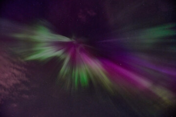 A purple and green aurora with a green and purple streak