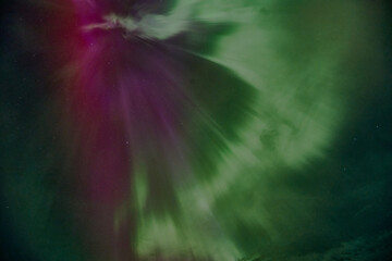 A purple and green aurora with a green and purple streak