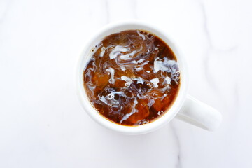 淹れたてのコーヒーが入ったマグカップを、真上から俯瞰した画像