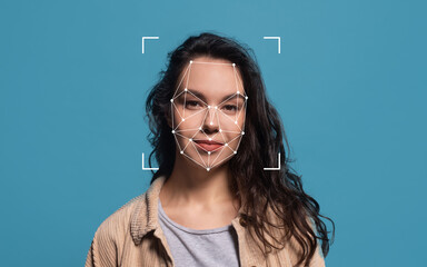A woman with curly hair stands against a blue background, showcasing facial recognition technology...
