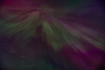 A purple and green aurora with a green and purple streak