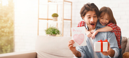Happy Father Day, adorable girl greeting her daddy with gift and self-made card, dad is happy, copy space