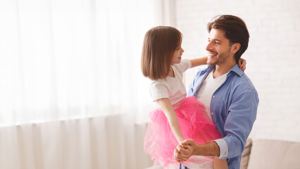 Loving father and little princess daughter dancing waltz at home, dad holding girl