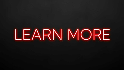 Obraz premium Learn More red neon lettering on plain black dark background
