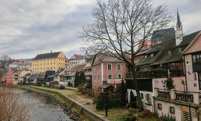 Explore the charming riverside architecture of Cesky Krumlov in the tranquil morning light beside the winding Vltava River