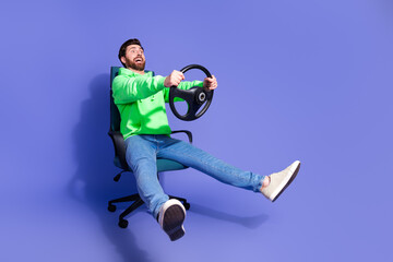 Full body photo of attractive young man ride armchair steering wheel dressed stylish green clothes...