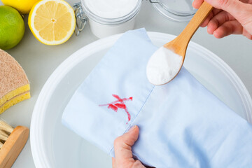 Female hands showing sprinkled with soda baking cosmetic stains on the blue clothes in a plastic...