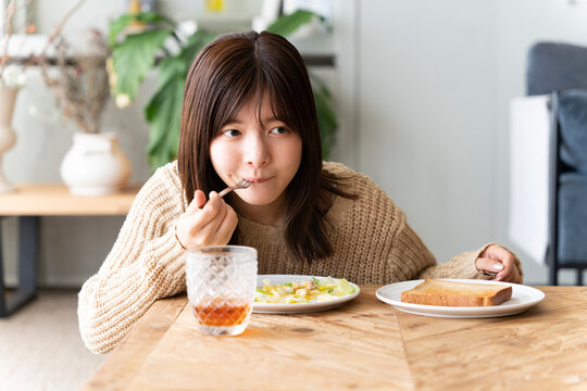 朝ごはんを1人で食べている女性