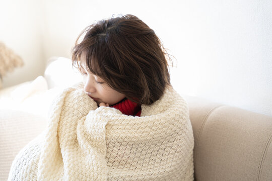 ブランケットにくるまって目を閉じている女性