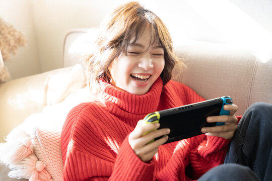 ソファでゲームを楽しんでいる女性