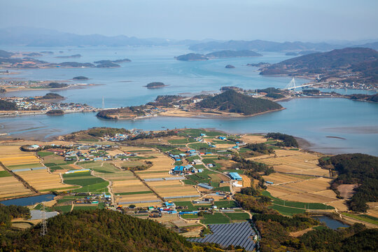 Aerial view of rocky Dalmasan Mountain in autumn with the background of farming village and Wando Island near Haenam-gun, Jeollanam-do, South Korea