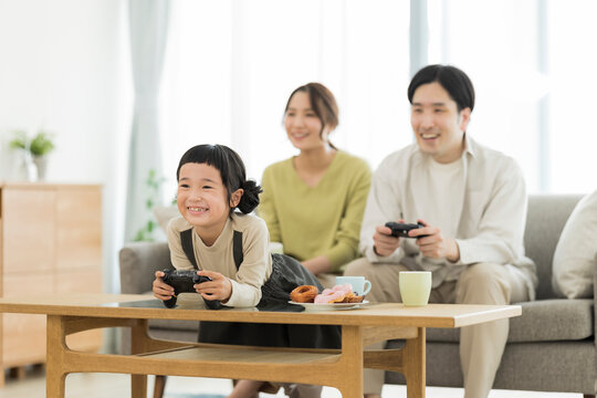 テレビゲームで遊ぶ家族