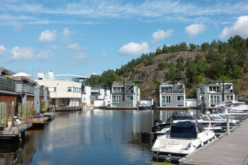 Fototapeta premium Marinstaden marina inspired locality in Nacka, Sweden, unique architecture with houses built on the water and boats moored