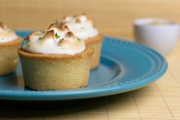 Tartlets with white cream baked on a blue plate, delicious dessert