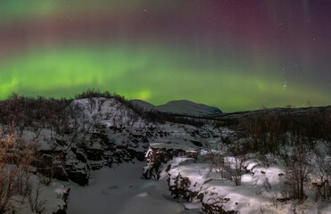 Obraz premium Beautiful aurora borealis over the snowy landscape Abisko