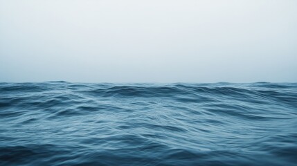 Fototapeta premium A minimalist image of ocean waves rolling softly toward the shore, with a wide-open horizon in the distance