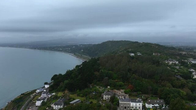 Killiney, County Dublin, Ireland, September 2024. Drone pushes forward above Sorrento Road toward Torca Road on Dalkey Hill facing west with Killiney Hill and the The Obelisk on the horizon.