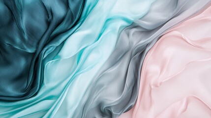 Obraz premium Flowing silk fabric in turquoise, teal, green and pink is laying on a flat surface and forming elegant waves, creating an abstract background