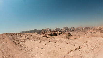 Exploring the stunning landscape of Petra in Jordan on a clear day with breathtaking rock formations and desert vistas