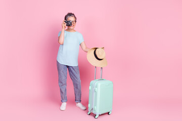 Full size photo of pretty aged woman suitcase photocamera empty space isolated on pink color background