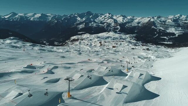 Aerial drone view of Madonna di Campiglio and ursus snowpark in Val Rendena dolomites trentino Italy. Snowboarder skier jumps on kicker in snowpark.