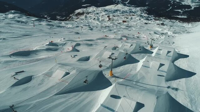 Aerial drone view of Madonna di Campiglio and ursus snowpark in Val Rendena dolomites trentino Italy. Snowboarder skier jumps on kicker in snowpark.