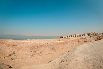 Lush views of the Dead Sea region in Jordan showcasing the arid landscape and tranquil waters under a clear sky