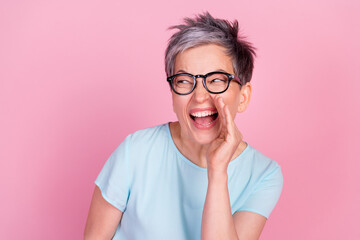 Photo of nice aged woman communicate empty space blue t-shirt isolated on pink color background