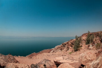 Stunning view of the Dead Sea from the rocky shores of Jordan on a clear sunny day
