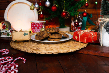 Freshly baked Christmas cookies placed on a plate among Christmas decorations on Christmas Eve, Christmas food and celebration concept