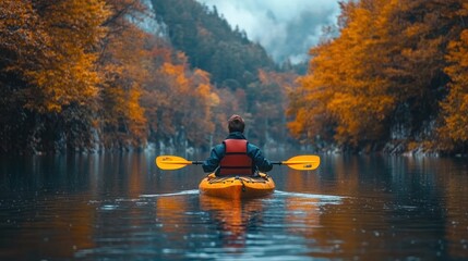 A person kayaking through a serene, autumn-colored landscape.