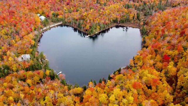 Aerial view of heart shape lake surrounded by autumn forest. Concept of earth day, love, environment, ecology. Baker Pond, Bolton-Est, Quebec, Canada.