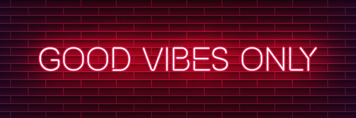 Neon sign reading "Good vibes only" on a dark brick wall
