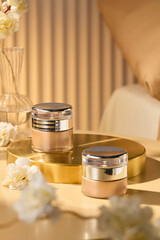 Photo template with two gold cream jars on a tray in the platform, adorned with delicate white...