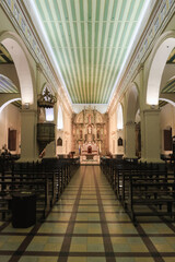 Historic church interior in Asuncion, Paraguay with ornate altar and wooden pews, showcasing...