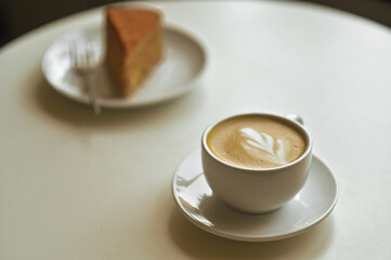 cappuccino latte cup with cake on the table