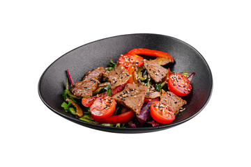 Warm salad with beef, tomatoes and sesame seeds on a black plate