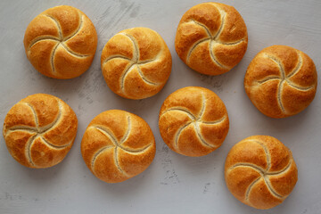 Homemade Kaiser Rolls on a wooden board, top view.