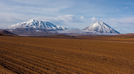 Panoramic view of Siloli Desert with the background of snow covered Licancabur Volcano at Altiplano, Bolivia