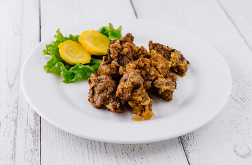 Delicious beef stew with potatoes and onions lying on white plate on white background
