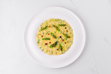 Creamy risotto being served with asparagus and pancetta