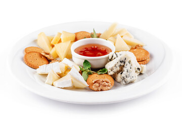 Delicious cheese plate presenting variety of cheeses, nuts, and sauce
