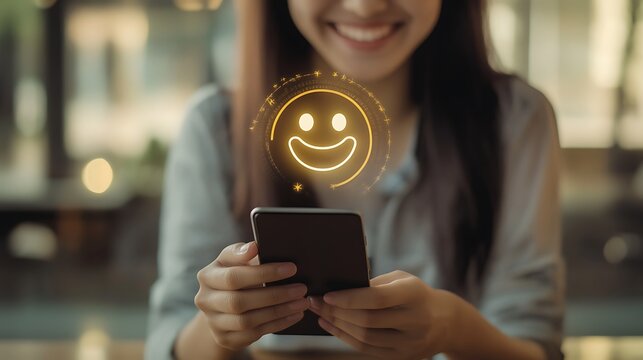 A close-up of a woman's hands holding a smartphone with a glowing smiley face icon above it, symbolizing positive feedback or a good experience.