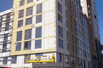 The process of insulating external walls in a multi-storey building under construction