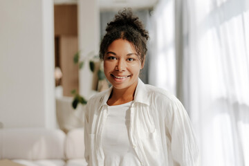 Young black woman smiling in her modern apartment