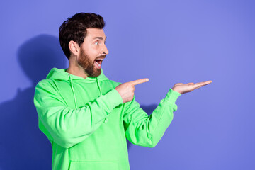 Photo of handsome mature age funky man wearing bright green hoodie promoting holding hand free...