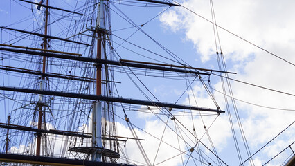 Fototapeta premium Shkots, halyards, braces on ship mast, blue sky and sea background, sailing.