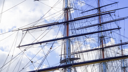 Shkots, halyards, braces on ship mast, blue sky and sea background, sailing.